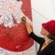 Anke Domscheit-Berg signiert Friedensplakat mit weißer Taube auf rotem Grund